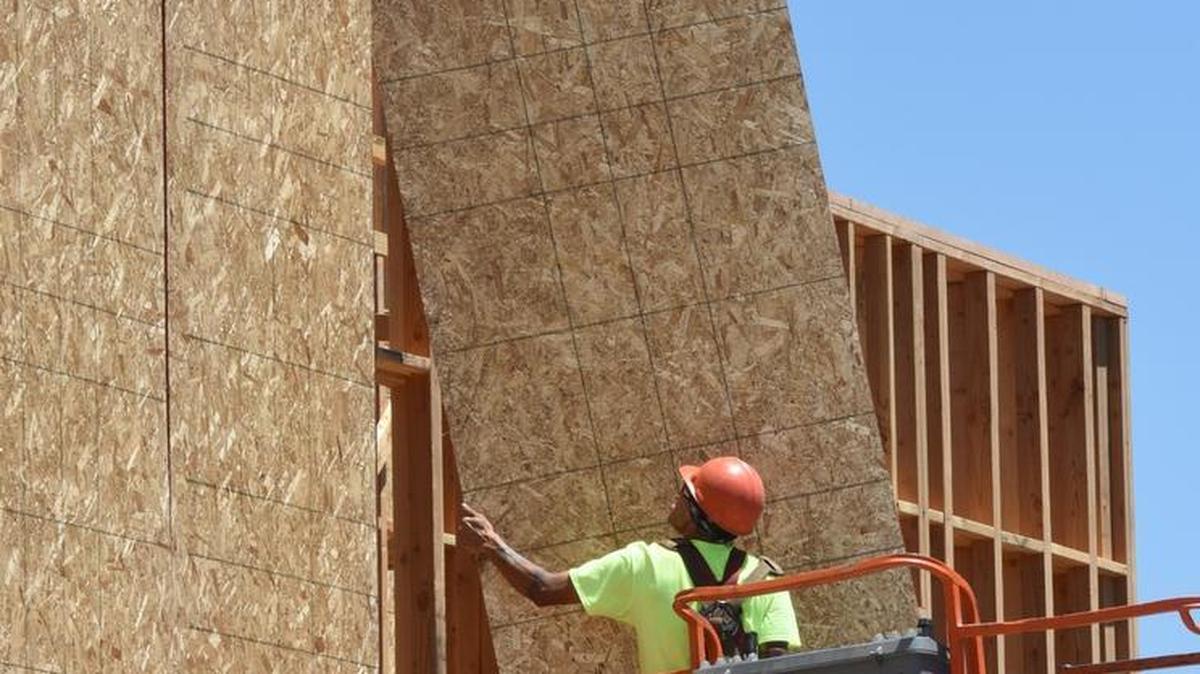 
A worker with Blades General Contracting lifts a board into place as he puts up a wall in late June at the Tower Park senior housing under construction at 17th and G streets in downtown Modesto. Construction was one of seven employment classifications in the state to see job gains.
