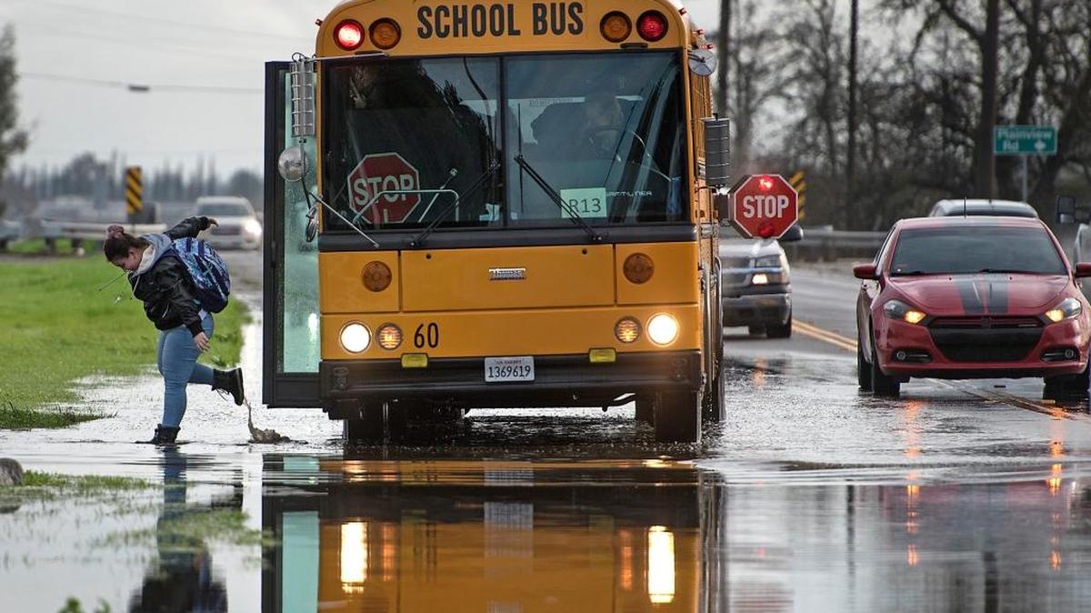 A student is dropped off along a flooded section of Claus Road at the entrance of Olive Lane Mobile Estates north of Modesto on Friday.