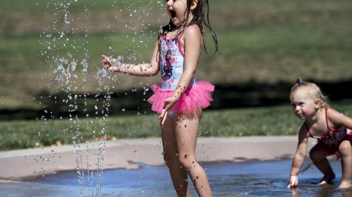 Miley Richey, 3, left, and Hollyn Salvi, 2, play in the water feature at Coffee Claratina Park in Modesto, Calif., on Friday, July 22, 2016.