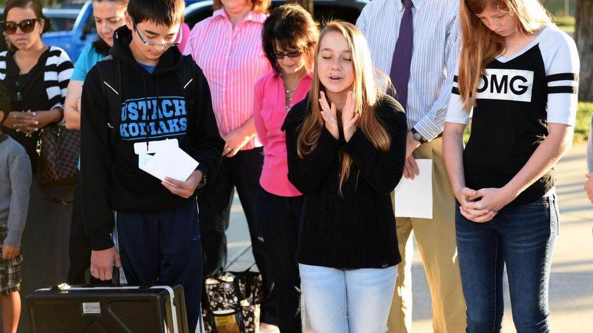 
Ustach Middle School student Mariah Fisk, 13, center, prays Wednesday, Sept. 23, 2015, with fellow students Nathanial Nishida, 12, left, and Logan Kayser-Sprouse, 13, right, at a prayer-at-the-pole event at the school in Modesto.

