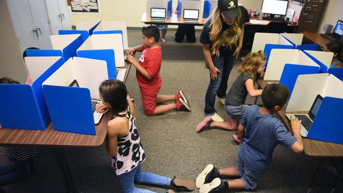 Student support specialist Daisy Torres-Perez helps students vote in student council elections at Carroll Fowler Elementary School in Ceres, Calif., on Friday, Sept. 30, 2016.