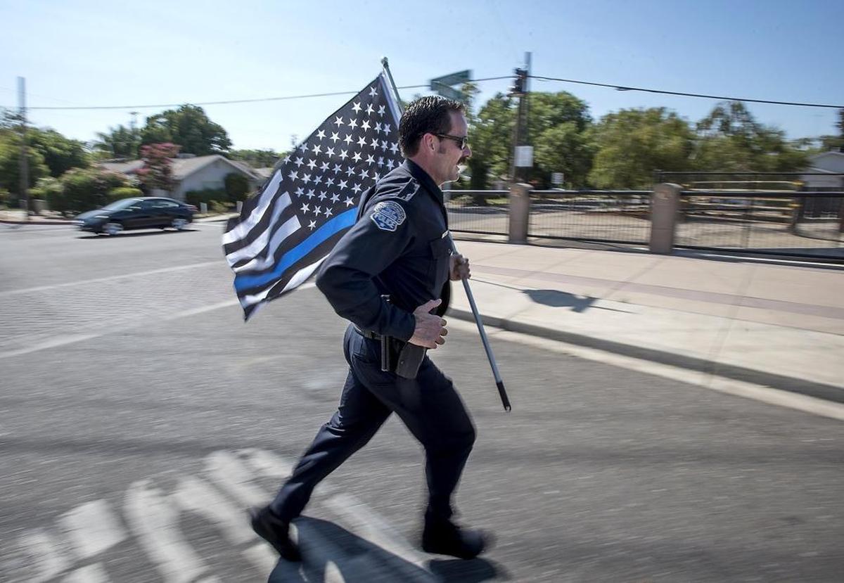 In early August 2016, Modesto police Detective Sean Dodge crosses West Morris Avenue during a 5-mile training run, in full uniform including boots, in preparation for that year’s Peace Officer Memorial Run half marathon.