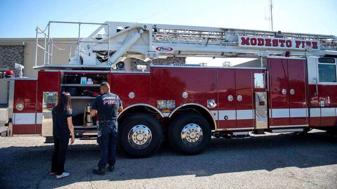 During a 2014 visit to a Modesto Fire Department station, firefighter Jose Valenzuela shows Modesto High School junior Yunah Kim, a Leadership Academy participant,  tools on a ladder truck.