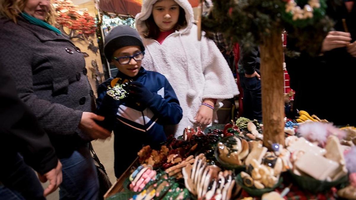 Paula Diaz, of Merced, looks at ceramic ornaments with her children Aizik, 7, and Charlotte, 9, at the Sonora Christmas Festival at the Mother Lode Fairgrounds in Sonora on Friday, Nov. 27, 2015.