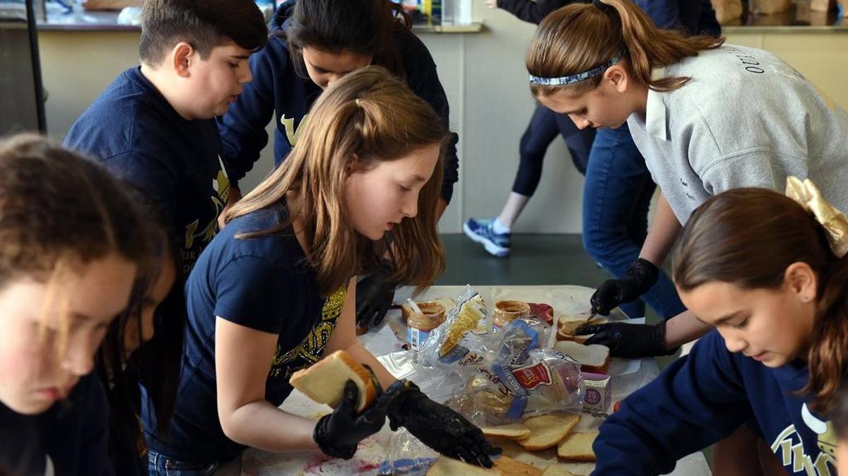 Our Lady of Fatima Catholic School students make sandwiches for the Modesto Gospel Mission on Monday, including, at center left, Elise Gary, 10, and, at far right, NatalieTrujillo, 10.