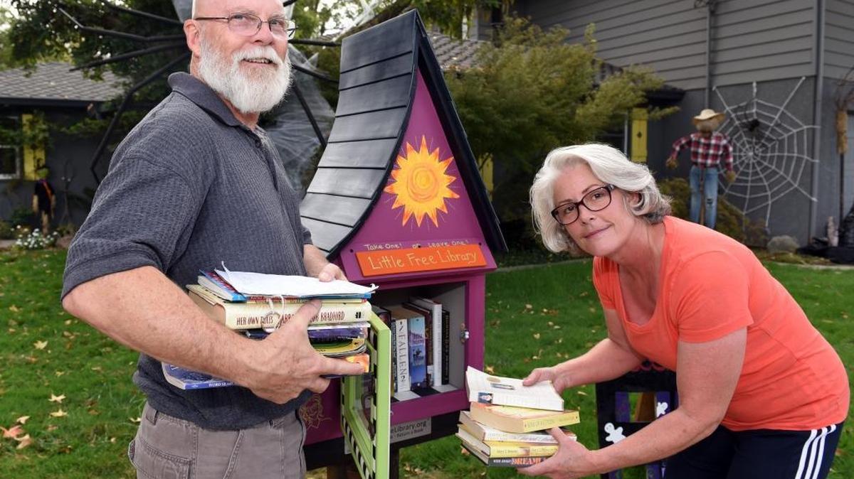 
Vicki and Marty Reid are pictured Thursday morning, Oct. 15, 2015, at their Modesto home with their Little Free Library. People take and leave books for readers of all ages, at will.

