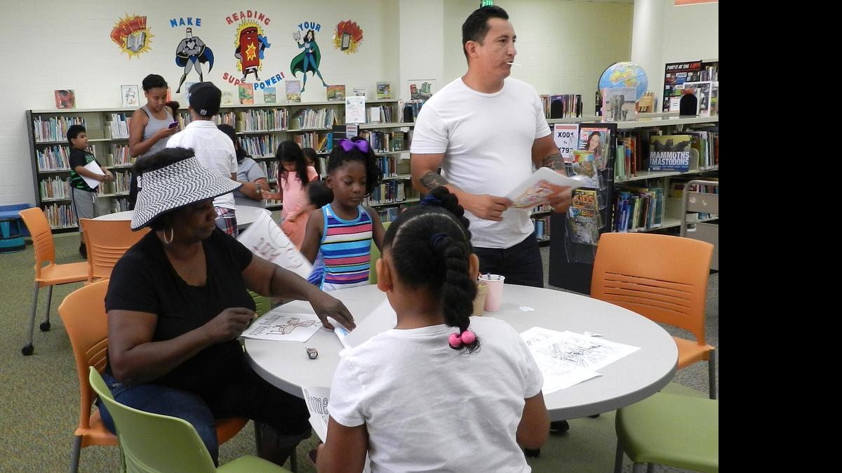 
Families work on coloring pages and a lollipop craft at Ceres Library on Magnolia Street last week.
