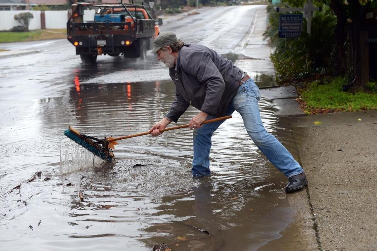 Modesto resident John Sims clears a storm drain that flows into Dry Creek on Tuesday morning, Jan. 5, 2016, on La Loma Avenue. The morning rain was heavy, causing flooding in many areas of Modesto.