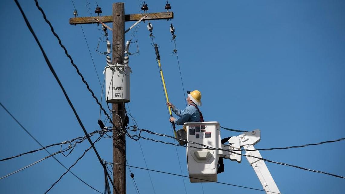 A Turlock Irrigation District worker restores power to residents in the Riverdale area in southwestern Modesto, Calif., on Wednesday, Feb. 22, 2017.