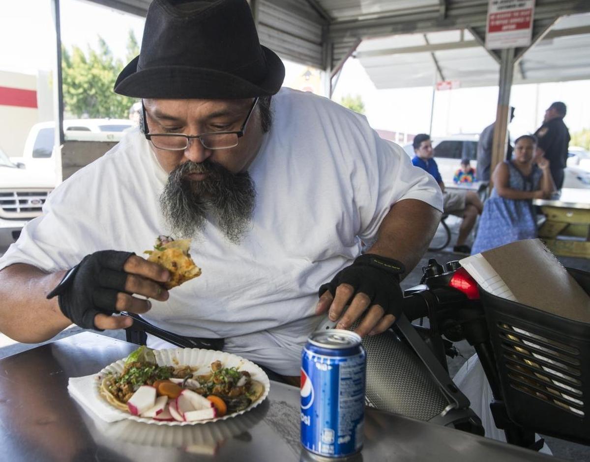 Enrique Escobedo of Modesto takes a bite of his Jessica’s Taquerias Truck chicken tacos Sunday Sept. 17th 2017.