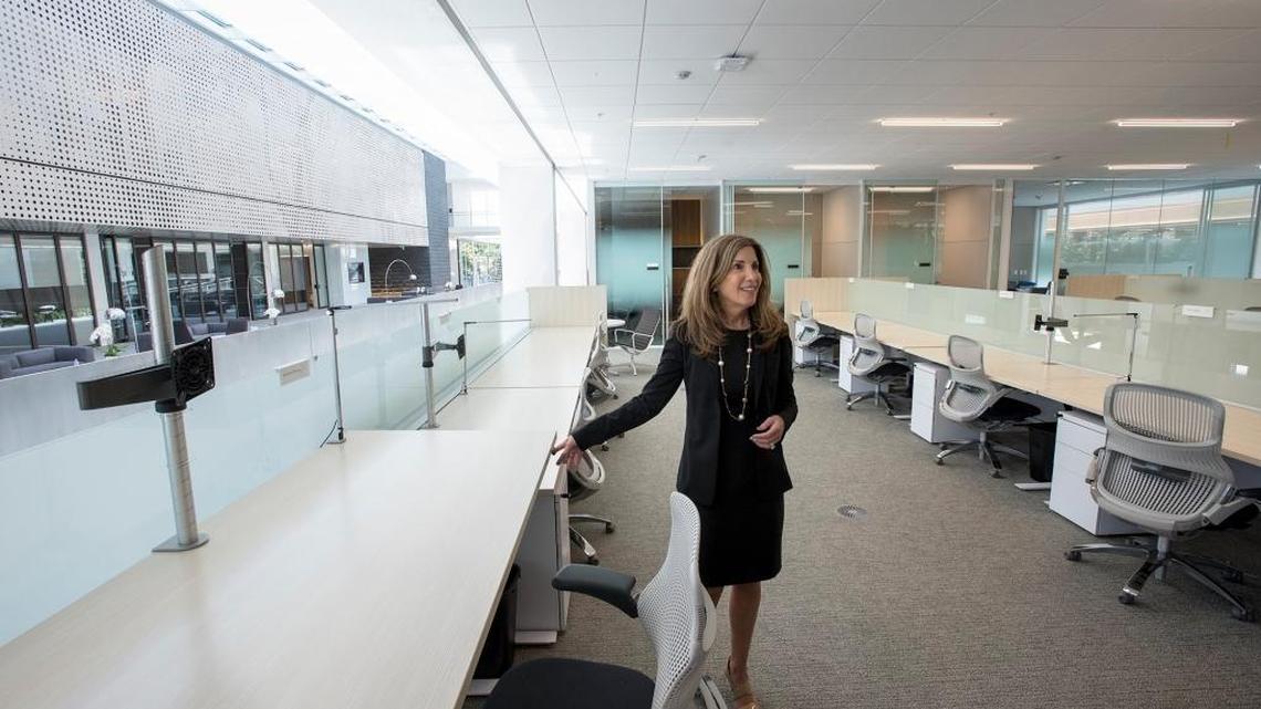 Gallo Vice President of Human Resources Michelle Lewis demonstrates a desk that can be used in a sitting or standing position in the new Dry Creek office building at the E.&J. Gallo Winery in Modesto, Calif., on Tuesday, August 30, 2016. The building will house more than 600 employees.
