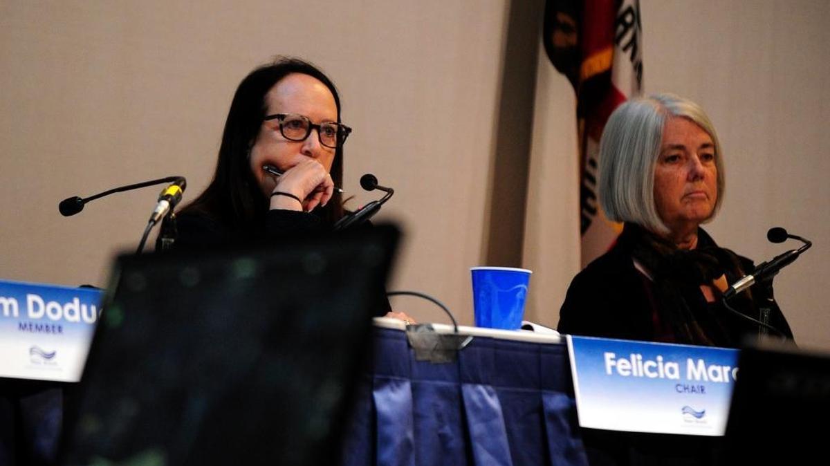 Board Chairwoman Felicia Marcus, left, and member Francis Spivy-Weber listen to elected officials speak at the State Water Resources Control Board hearing at the Merced Theatre on Dec. 19 in Merced.