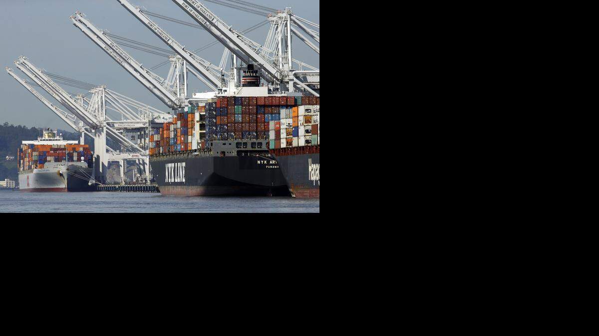 
Container ships wait at the dock to be unloaded at the Port of Oakland last month. “Cargo is moving and the backlog is shrinking,” since a tentative labor pact was reached following a labor dispute, said Maritime Director John Driscoll.
