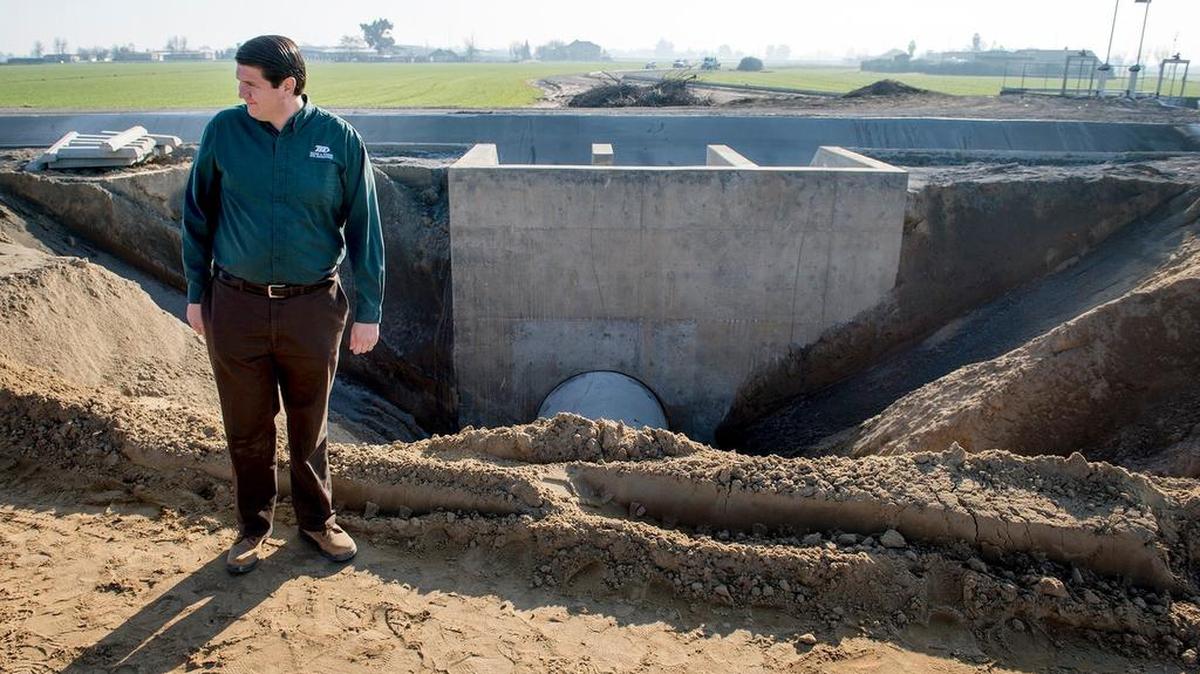 Turlock Irrigation District engineer Matt Hazen looks out at the work being done on a reservoir in January beside the Highline Canal in Hilmar. The disctrict will use a small, abandoned reservoir to catch overflow from the canal.