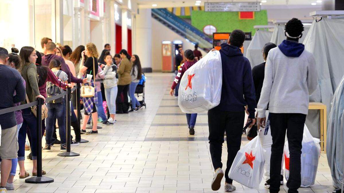 Shoppers carry full bags from Macy's during the Black Friday Sale on Thanksgiving Day, November 23, 2017, at the Vintage Faire Mall in Modesto California. An economic forecast shows a slowdown in the valley economy's' growth, and retail could be headed for even more of one this year.