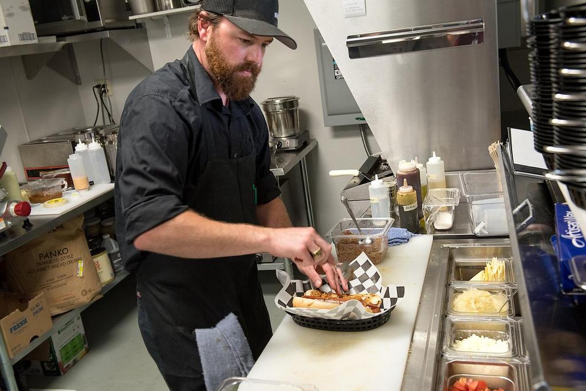 Head Chef Dane Barry dresses a hot dog at Graffiti Dogs restaurant in Modesto, Calif., on Thursday, September 6, 2018.