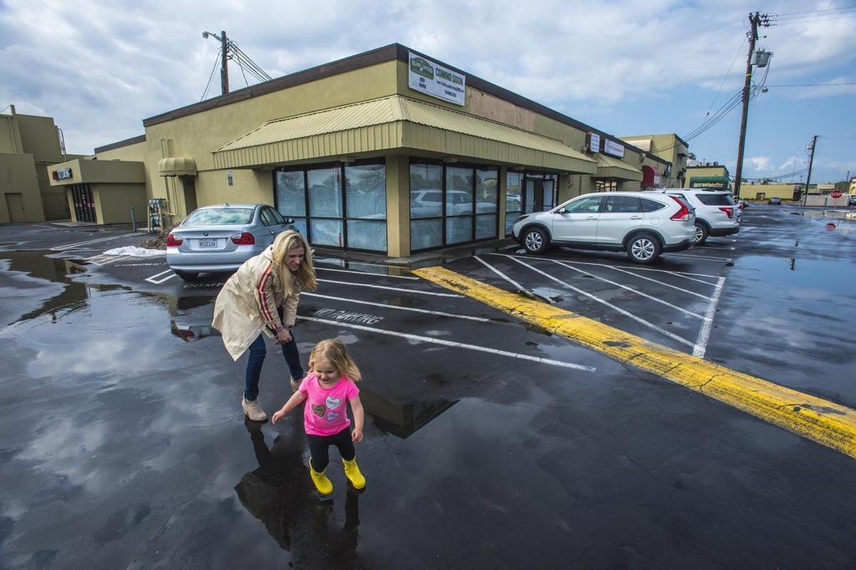 Stacy Soderstrom watches her daughter Reagan, 3, as she splashes the puddles in front of their family’s new artisan butcher shop, The Village Butcher, on Saturday, March 23, 2019, at McHenry Village in Modesto. Matt Soderstrom, a Modesto native, plans to open the full service butcher shop and deli in May.
