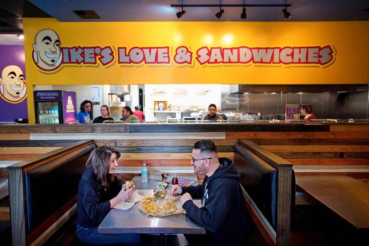Arno Lopez, right, and Janis Sisson, left, eat lunch at Ike’s Love & Sandwiches in Modesto in January 2019.