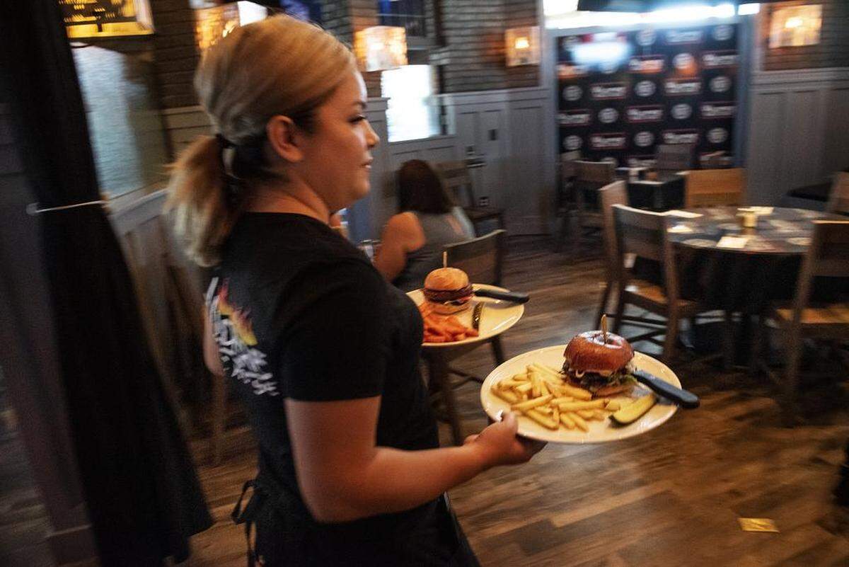 Manager Kathy Montoya delivers lunch meals at Wildfire Public House in Modesto, Calif., Friday, June 21, 2019.