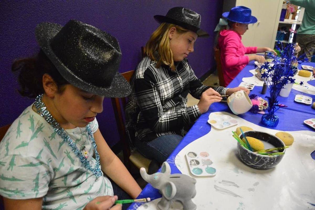 Emily Flora (center) and Gianna Genasci (left) paints at Pottery Magic Modesto Saturday, March 3, 2018.