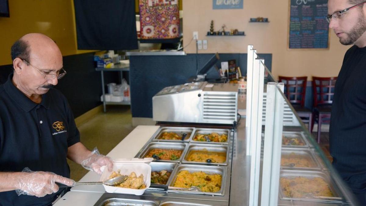 Biryani Express owner Pervaiz Bhatti (left) serves up lunch for customer Joseph Fernandez of Modesto. The Indian and Pakistani food restaurant opened in late 2017 at 3900 Pelandale Ave in Modesto, Calif.