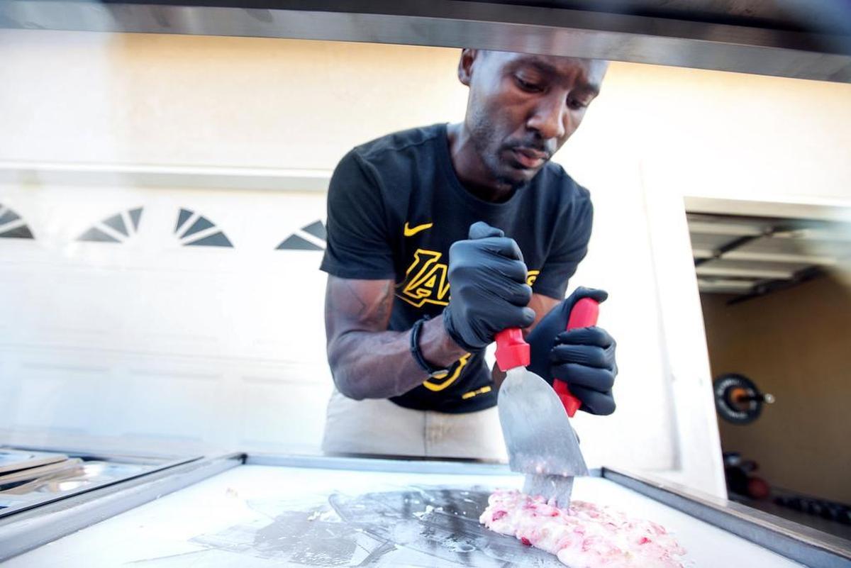 Blossoms Creamery co-owner Cameron Robinson mixes toppings into cream as he demonstrates how he makes rolled ice cream in Modesto, Calif., on Tuesday, Oct. 2, 2018.