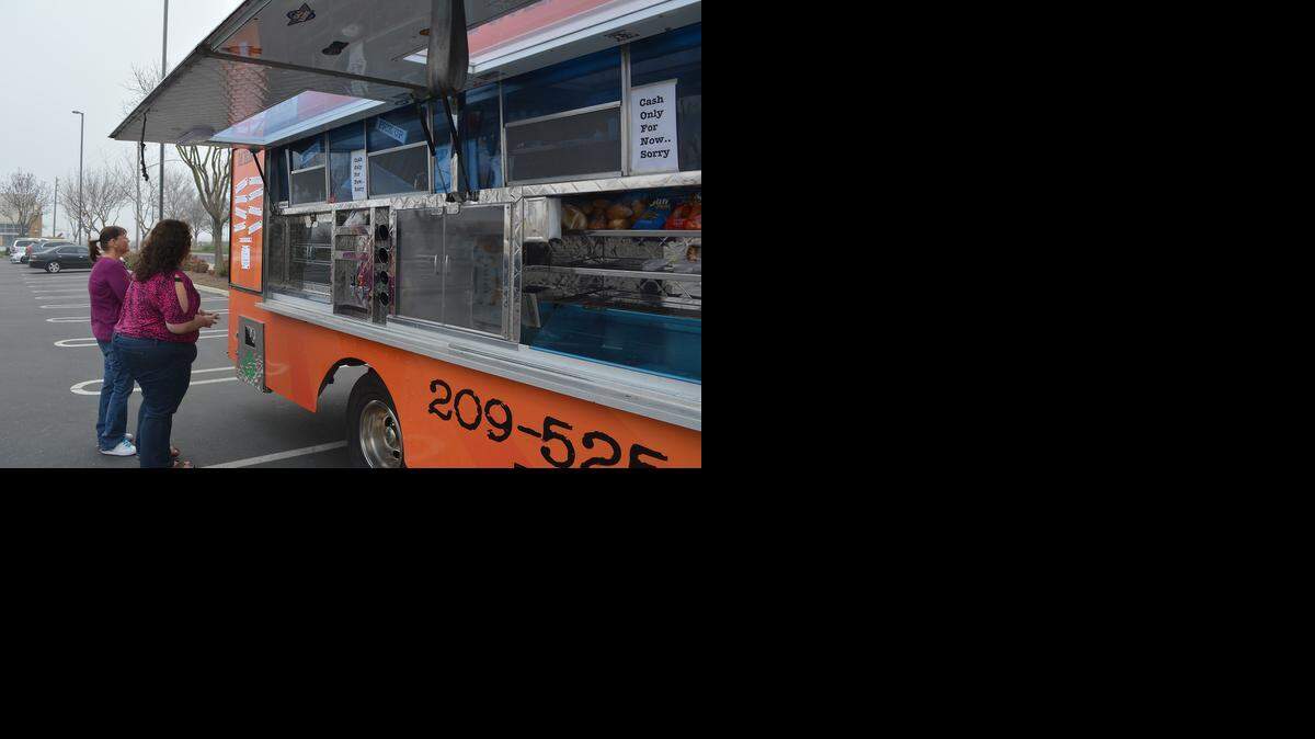 
Customers line up to order at the Food Fix truck, which was parked in the Best Buy parking lot on Sisk Road in Modesto on Wednesday.
