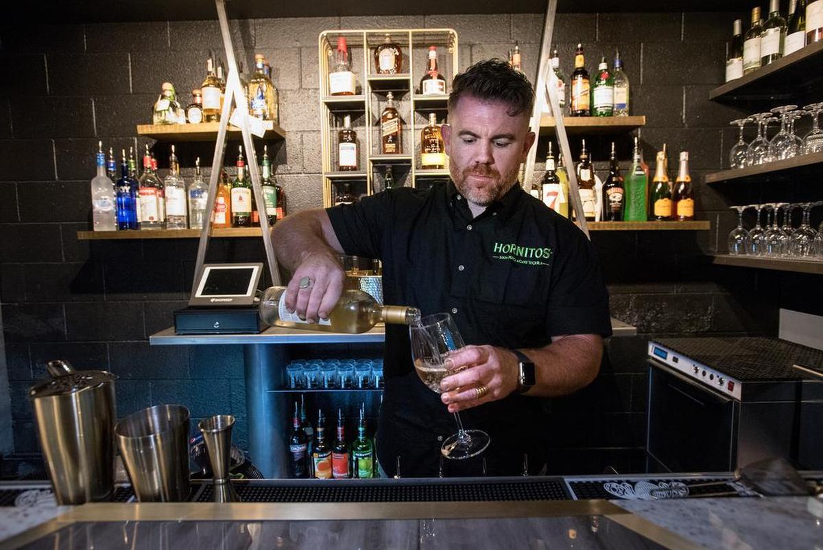 Owner Adam Soares pours a glass of wine at Blades and Bottles in Modesto, Calif., Friday, Jan. 25, 2019.