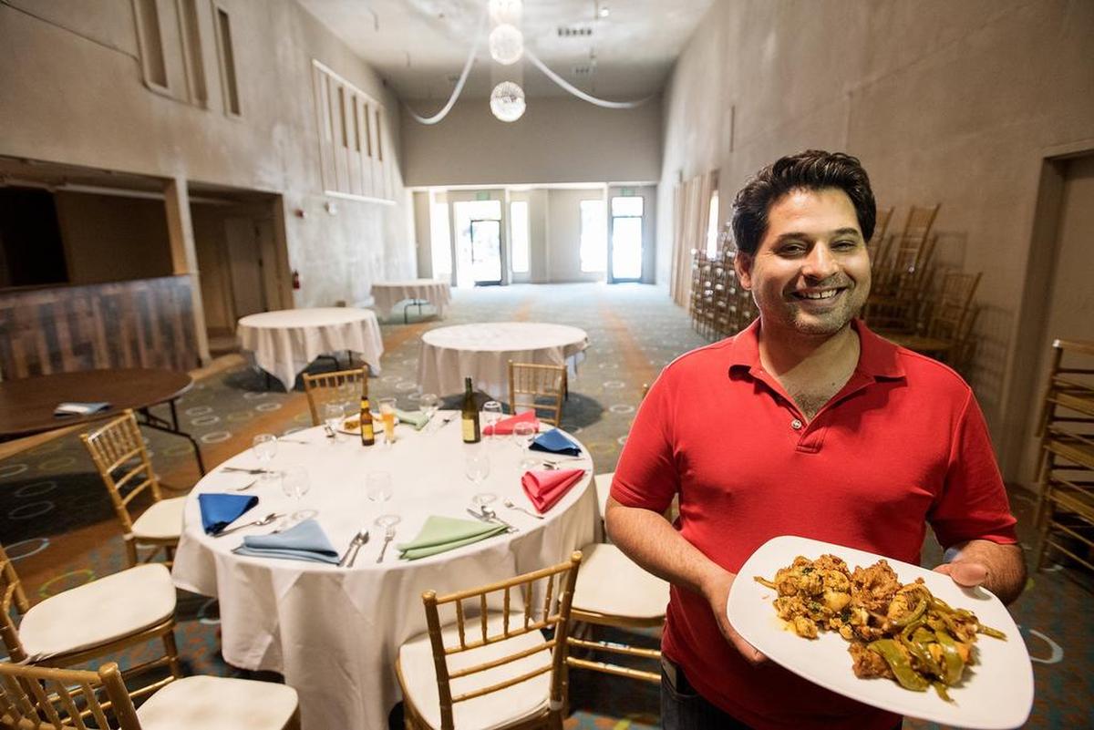 Gurinder S. Khaira holds a plate with Tandori Chicken and vegetables in their newly renovated banquet space at Monsoon Restaurant in Modesto, Calif., September 5, 2018.