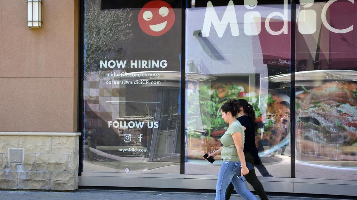 Shoppers walk by a hiring sign at Vintage Faire Mall Sept. 26, 2018 in Modesto, Calif. Retailers across the Central Valley have already started hiring for the holiday season.