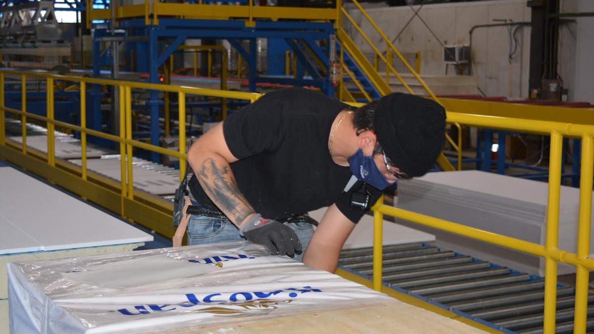 Kevin Rentería ayuda a fabricar paneles aislantes en la planta de Kingspan, en Ceres CA, el 1 de junio de 2021.