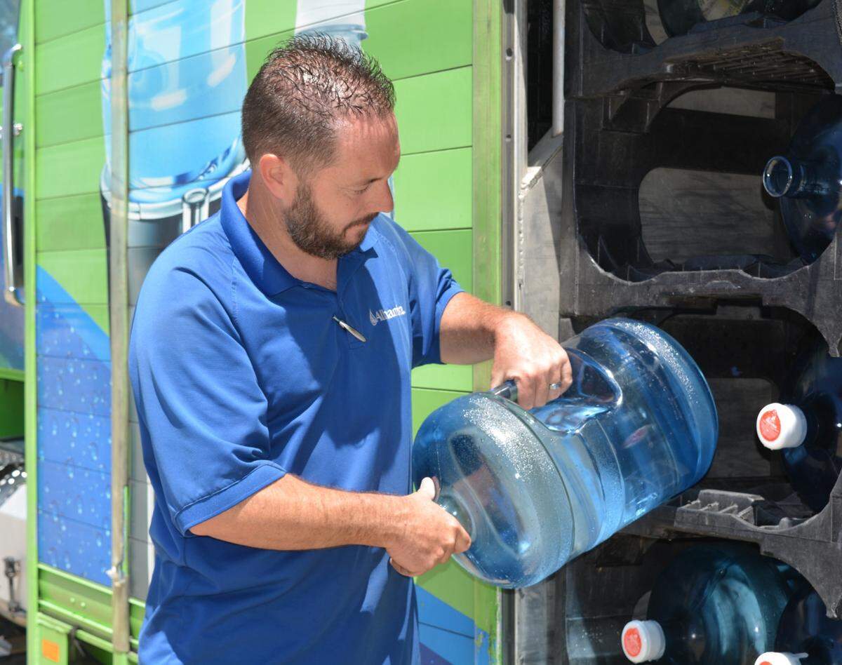 Alhambra driver Tim Halloran delivers free water to a home just south of Turlock, CA, on Friday, May 28, 2021. The jugs are being provided to homes with hazardous nitrate levels in their wells under a new program funded by farmers and other parties.