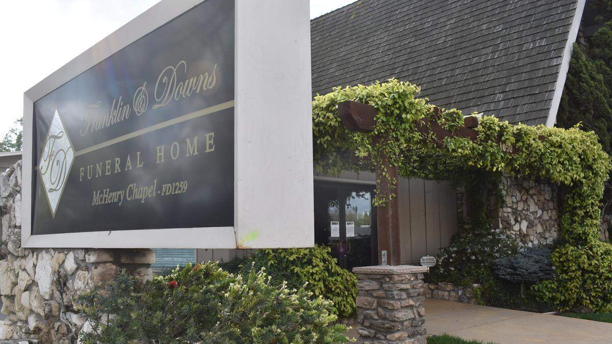 Notices on the doors of the Franklin & Downs Funeral Home on McHenry Avenue in Modesto explain the location is closed to the public because of the statewide stay-at-home order but remains an essential service. The mortuary asks people to call by phone to be assisted.