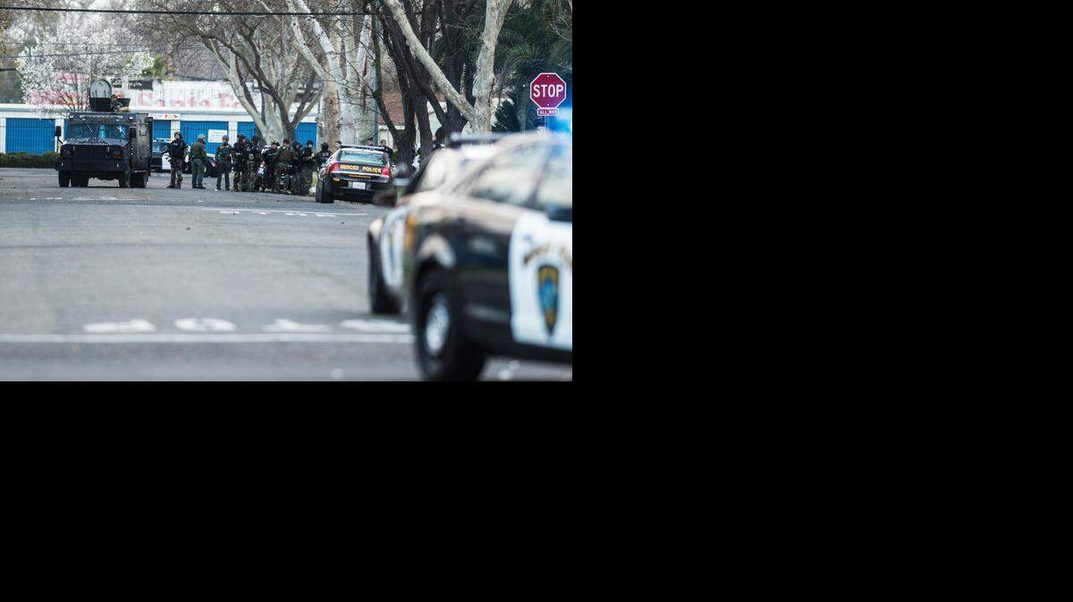 The Merced Police SWAT team lines up near  I  and West 23rd streets while searching for a shooting suspect.