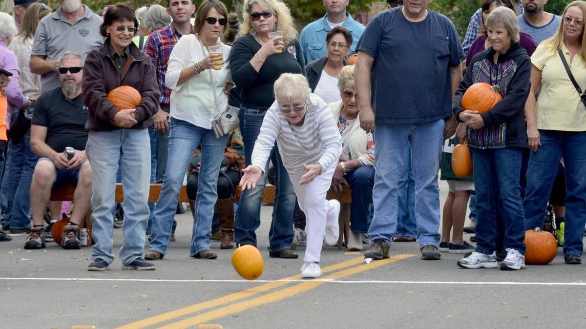 Bev Hay, 74, of Oakdale gives her pumpkin a roll. Hundreds came out for the Pumpkin Roll in the old town of Knights Ferry on Sunday. Participants rolled their pumpkins down Main Street to see whose pumpkin could get closest to a line without rolling off the street. This was the 53rd year of the event.