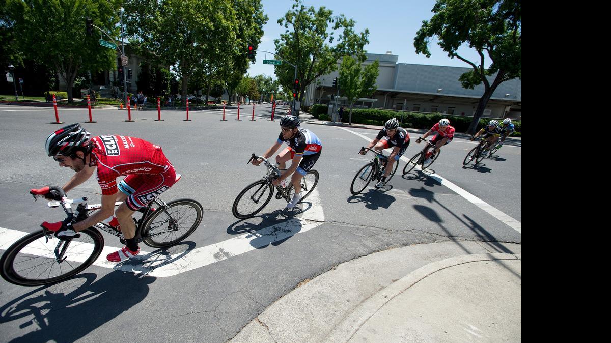 
Doran Mori, left, leads a pack around a corner on 14th Street during the Master 35 class race in the Modesto Criterium in Modesto on Saturday.
