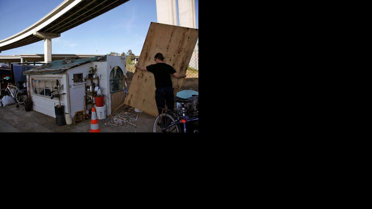 
Greg Kloehn moves a piece of wood given to him by a homeless man in Oakland.
