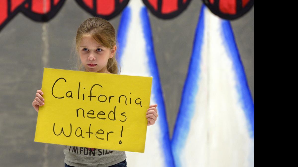
Neveah Craft, a third-grader in Capistrano Elementary School’s after-school program, holds a sign about the drought during a rehearsal for their talent show Monday afternoon.
