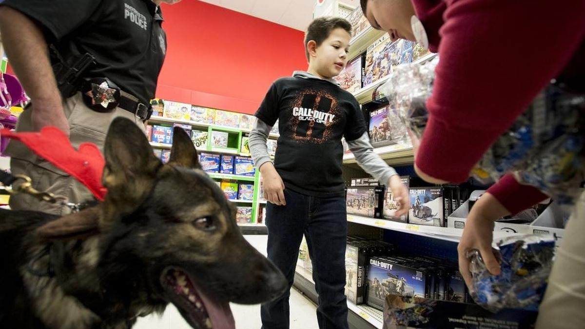 Last year, Logan Davis, 10, shops for toys with Modesto Police K-9 Volk, Officer Derrick Letsinger, left, and Target employee Karina Porras during the Heroes and Helpers program at Target in Modesto.