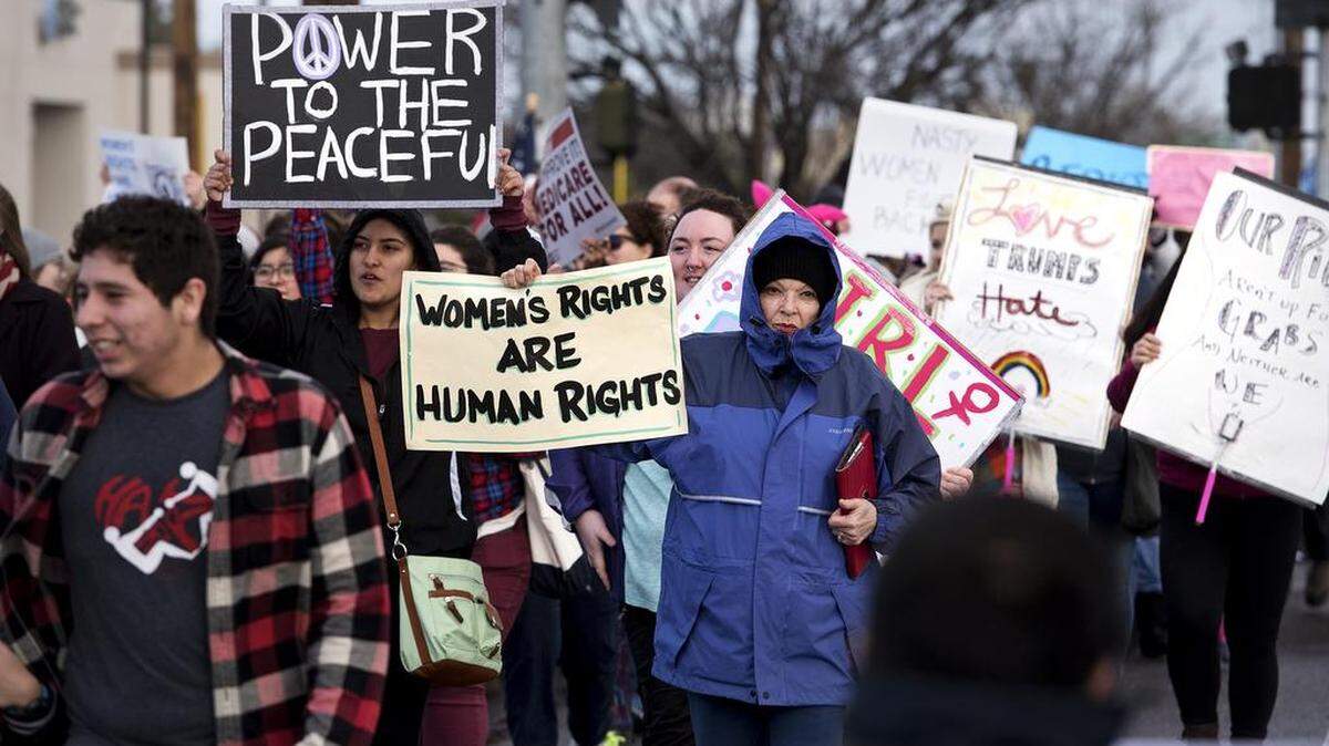 Participants including Isabel Santos, middle, march along McHenry Avenue in support of the Modesto Women's March in Modesto, Calif. on Saturday, Jan. 21, 2017