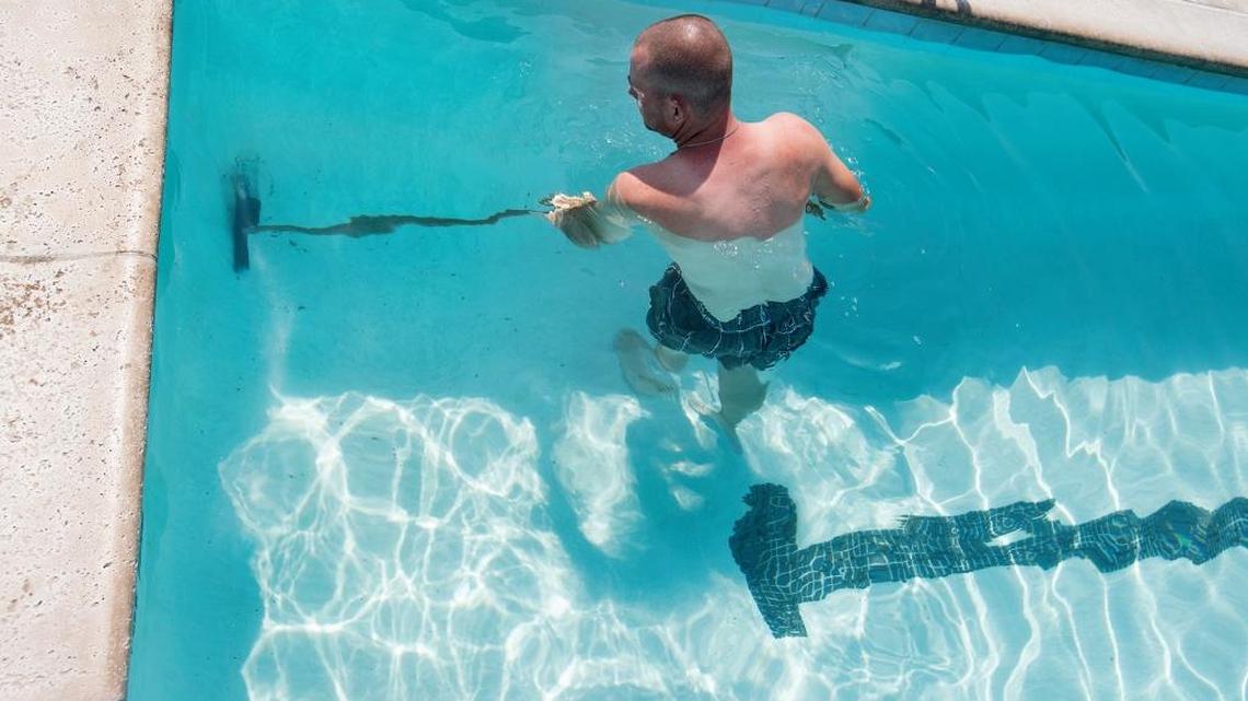 Stanislaus County maintenance worker Paul Childs cleans the pool at the Regional Water Safety Training Center in Empire on Monday, August 29, 2016. A proposed final county budget would provide for more full-time parks workers.
