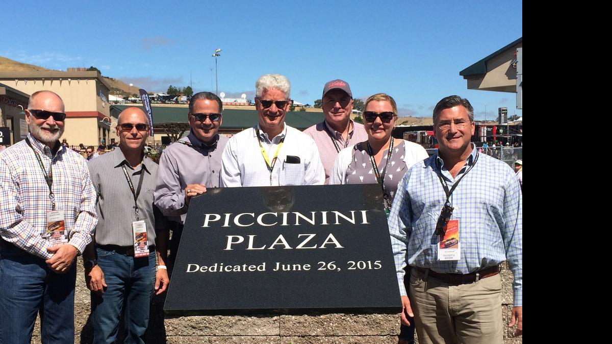 
At the Toyota/Save Mart 350 NASCAR race on June 28, the Sonoma Raceway honored the legacy of Bob Piccinini by renaming the area at Turn 11 after Save Mart's former Chairman and CEO. Race officials unveiled the new monument, marking the site now known as Piccinini Plaza. The company's co-presidents and general managers attended the dedication. . From left are Frank Capps, general manager, FoodMaxx; Greg Hill, co-president and chief financial officer; Steve Junqueiro, co-president and chief operations officer; Steve Page, Sonoma Raceway president and general manager; Randy Slenz, general manager, Save Mart; Nicole Pesco, co-president and chief strategy and branding officer; and Mike Haaf, general manager, Lucky.
