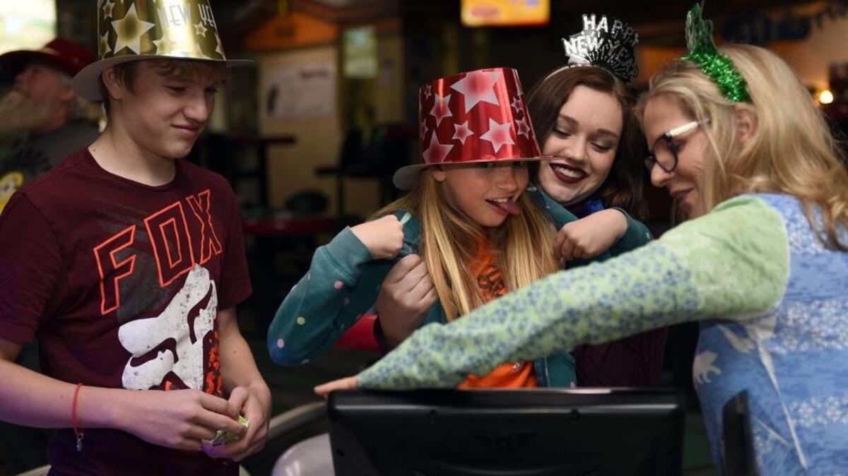 Brooklynn Erickson, 8, center, makes a silly face while checking her bowling score Saturday evening at Yosemite Lanes in Modesto, Calif. Also pictured from left are Wyatt Pahrman, Isabella Pahrman and Cyndi Heald