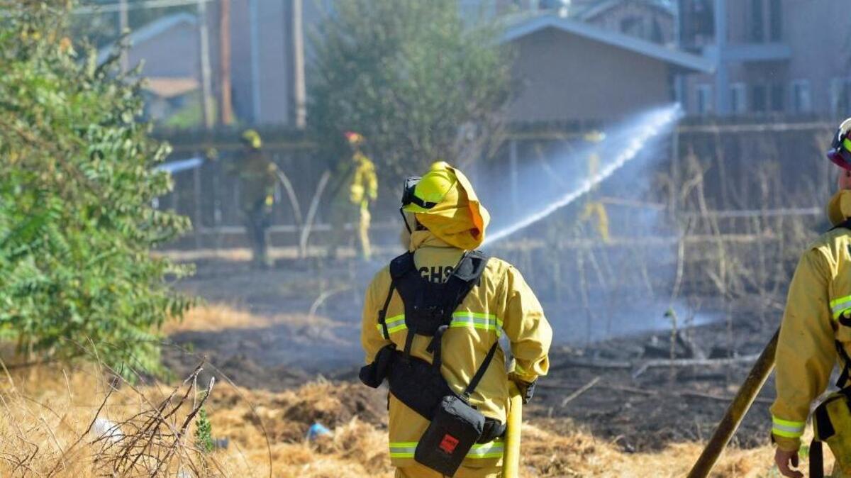 A firefighter helps in the mop-up of a four-acre fire in Keyes, Calif., on Tuesday, July 12, 2016.