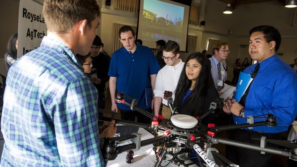 University of California, Merced students Erwynn Rueda, right, and Jaimee Balansa , second from right, learn about an "AL3", a Phoenix Arial Systems drone from Jefferson Laird, left, during the 2016 Ag Tech Fair on the University of California, Merced campus in Merced, Calif., Wednesday, March 2, 2016. The drone is based on a DJI S1000, which uses lasers and an RGB camera to help measure geomorphic change.
