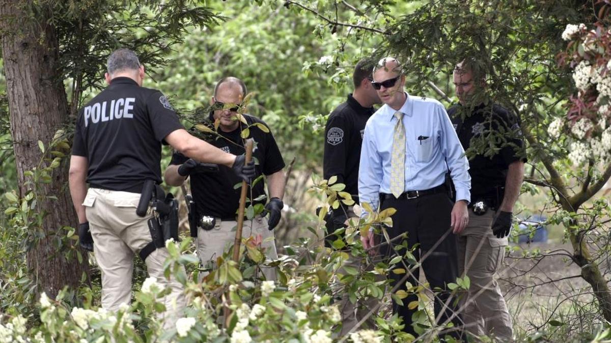 Detective Sgt. Steve Hinkley (second from right) searches with other detectives of the Modesto Police Department Wednesday afternoon (04-05-17) on Claus Road in Modesto, Calif. A woman’s body was found behind oleander bushes alongside Claus Road just north of Merle Avenue on Tuesday in Modesto, Calif.