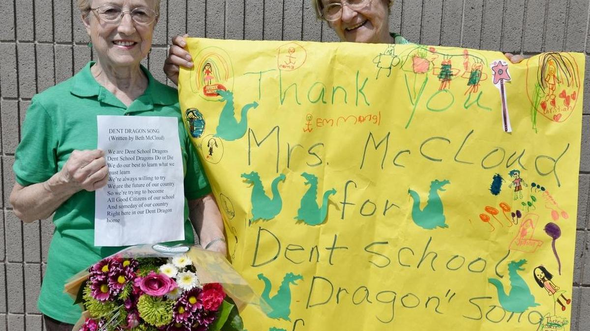 Beth McCloud, left, who taught school for 28 years in Escalon including 24 at Dent Elementary, holds up the lyrics of the “Dent Dragon Song” she penned in the 1980s, which is still sung each Friday by the students. They honored her last week by singing the song for her. Rosanda Amerine holds the banner students made.