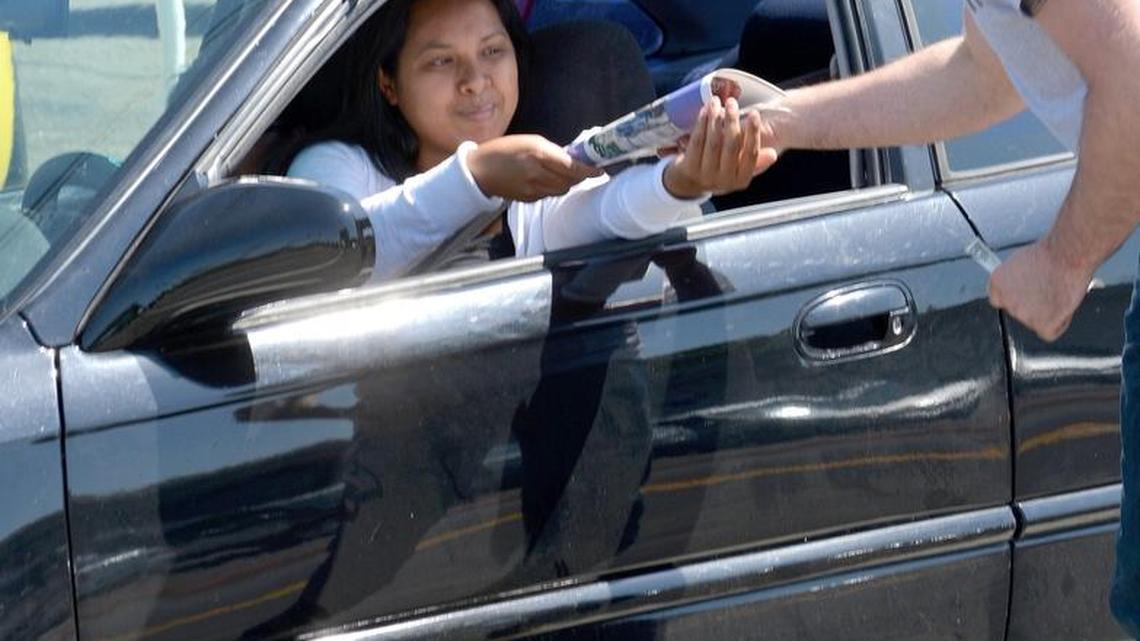 Jordan Herr, right, sells a Kids’ Day newspaper to a motorist at McHenry and Roseburg avenues in Modesto on Tuesday, May 10, 2016. He was part of a contingent from Modesto’s Franklin & Downs Funeral Home that sells papers each year on that same corner. The sales benefit the Salvation Army’s Red Shield Center, which works with at-risk youths.
