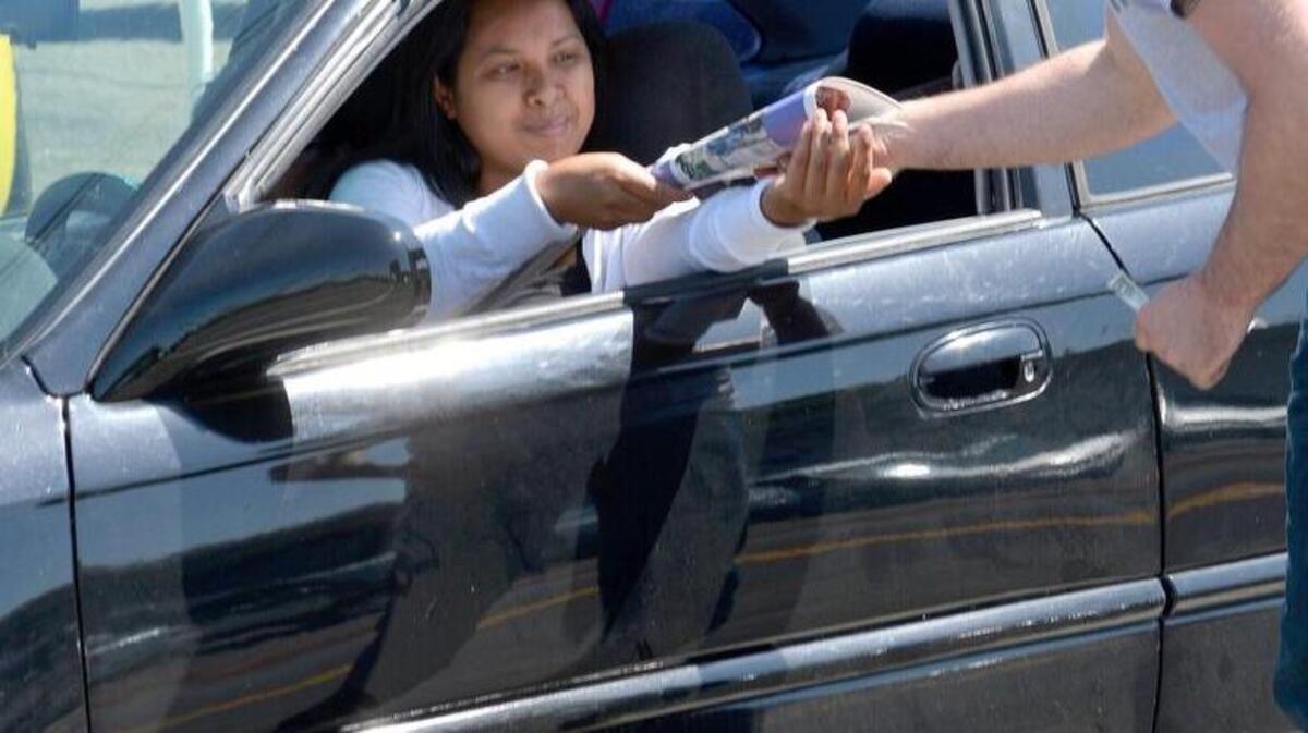 Jordan Herr, right, sells a Kids’ Day newspaper to a motorist at McHenry and Roseburg avenues in Modesto on Tuesday, May 10, 2016. He was part of a contingent from Modesto’s Franklin & Downs Funeral Home that sells papers each year on that same corner. The sales benefit the Salvation Army’s Red Shield Center, which works with at-risk youths.