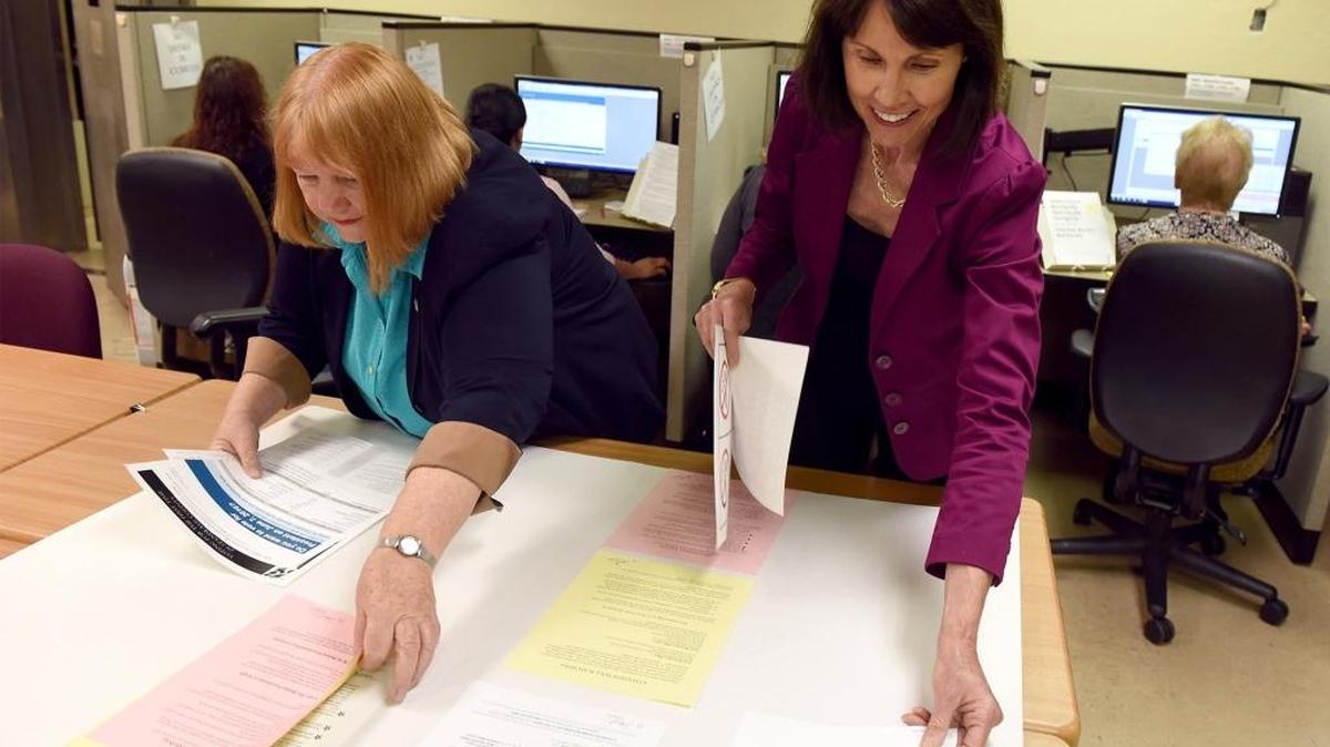 Registrar of Voters Lee Lundrigan, left, and Election Manager Marnie Ardis assemble election signs Wednesday, May 11, 2016, that will hang at the polls. Voters have received postcards that allow people registered as No-Party Preference to crossover into another party temporarily to vote for a presidential candidate.